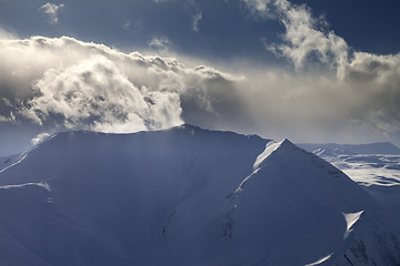 Image showing Mountains in evening with sunlit clouds