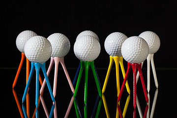 Image showing White golf balls and different colored tees