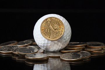 Image showing White golf ball and U.S. dollar coins