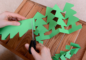 Image showing Cutting green card into a chain of Christmas trees