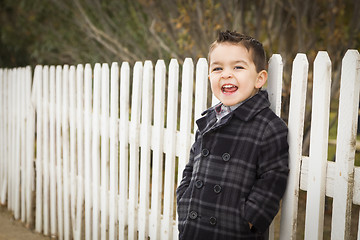 Image showing Young Mixed Race Boy Waiting For School Bus Along Fence