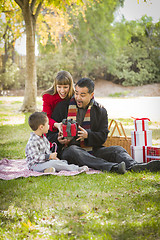 Image showing Mixed Race Family Enjoying Christmas Gifts in the Park Together