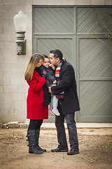 Image showing Warmly Dressed Family Loving Son in Front of Rustic Building