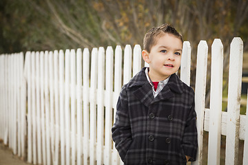 Image showing Young Mixed Race Boy Waiting For School Bus Along Fence Outside.