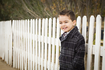 Image showing Young Mixed Race Boy Waiting For School Bus Along Fence Outside.