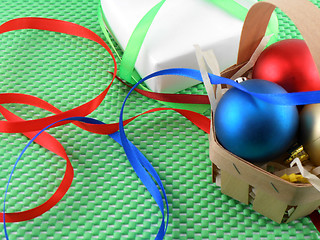 Image showing Christmas balls and white gift box on green background