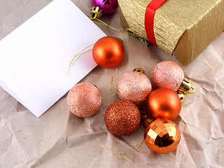 Image showing golden gift box with red bow and christmas balls set on old paper