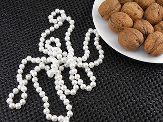 Image showing Walnuts on a white plate with white pearls