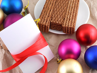 Image showing sweet waffles with christmas balls and white invitation card