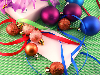 Image showing A white gift with a green ribbon and new year balls