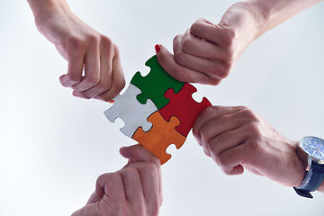 Image showing Group of business people assembling jigsaw puzzle