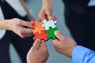 Image showing Group of business people assembling jigsaw puzzle