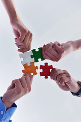 Image showing Group of business people assembling jigsaw puzzle