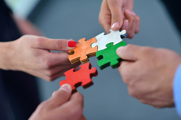 Image showing Group of business people assembling jigsaw puzzle