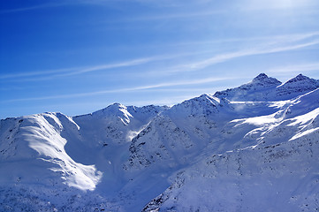 Image showing Snowy sunlight mountains at nice evening, view from off piste sl