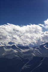 Image showing Winter mountain in evening and silhouette of parachutist