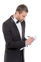 Image showing Handsome man in a bow tie writing notes