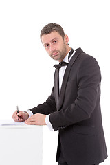 Image showing Man in a bow tie completing a form