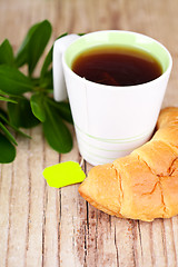 Image showing cup of tea and fresh croissant 