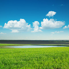 Image showing green lanscape with pond under blue sky