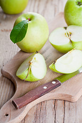 Image showing fresh green sliced apples and knife 