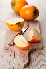 Image showing ripe persimmons and knife 