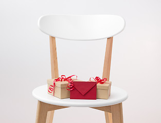 Image showing Gifts and red envelope on a wooden chair