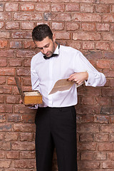 Image showing Man reading a document from a wooden box