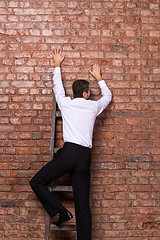 Image showing Man up against a brick wall