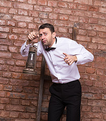 Image showing Scared man searching with an oil lamp