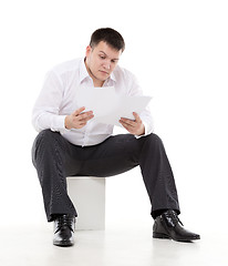 Image showing Businessman reading a report with scepticism