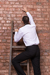 Image showing Man up against a brick wall