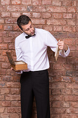 Image showing Man reading a document from a wooden box