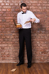 Image showing Man reading a document from a wooden box