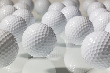 Image showing Many golf balls on a glass table