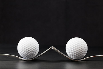 Image showing Golf balls on the black background