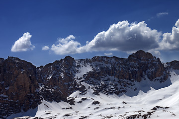 Image showing Snowy rocks and blue sky with cloud in sunny spring day