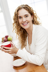 Image showing Smiling woman holding red coffee cup