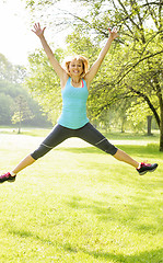 Image showing Smiling woman jumping in park