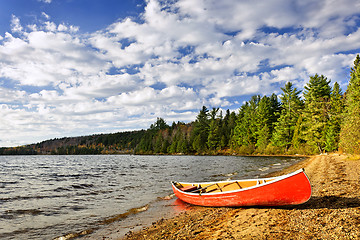 Image showing Red canoe on lake shore