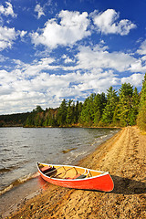 Image showing Red canoe on lake shore