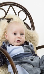 Image showing newborn child in chair with sheepskin