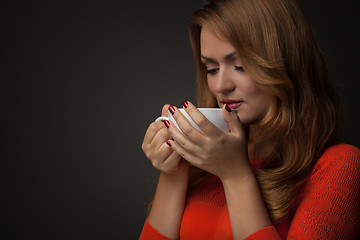 Image showing woman holding hot cup and smiles