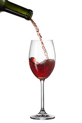 Image showing Red wine pouring into glass with splash isolated on white