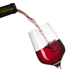 Image showing Red wine pouring into glass with splash isolated on white