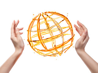 Image showing Globe from orange water with human hand isolated on white