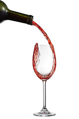 Image showing Red wine pouring into glass with splash isolated on white