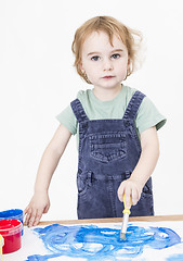 Image showing cute girl painting on small desk