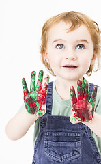 Image showing cute little girl with finger paint looking up