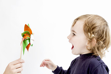 Image showing cute girl blowing to windmill